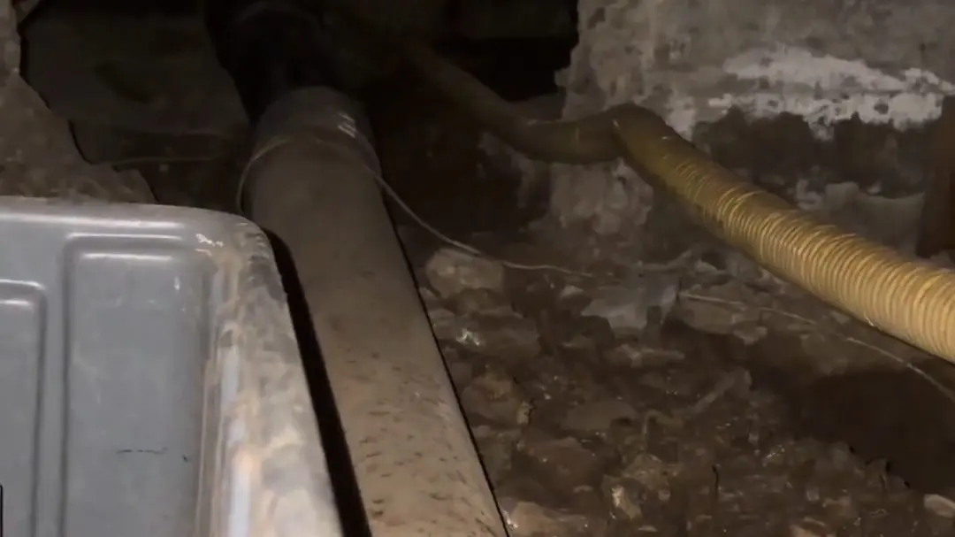 Crawlspace drain piping and cleanout work below a home during a plumbing service visit in Mariposa Altadena