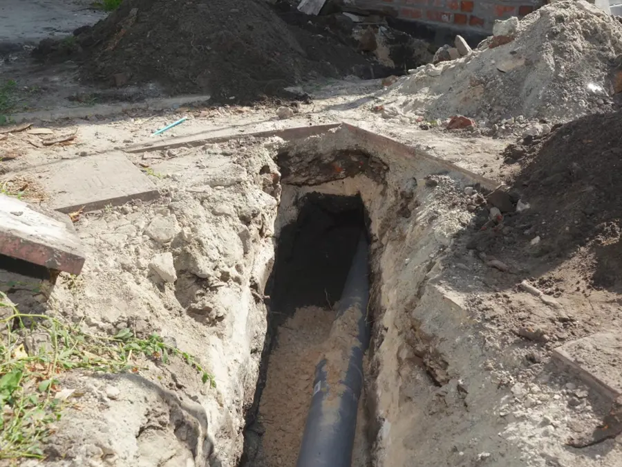 Exposed sewer pipe and repair access in soil related to Sewer Line Repair in Altadena, CA on the sewer-side-01 section