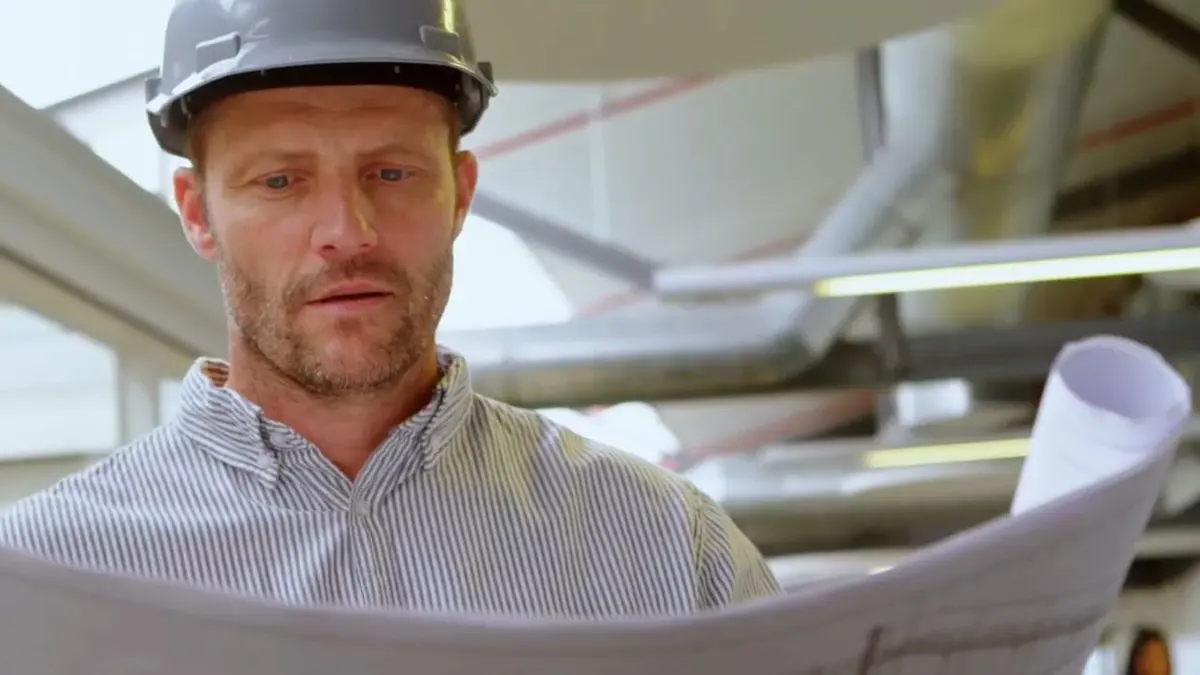 Plumber in a hard hat reviewing plumbing plans for Buying a 1920s Altadena Home? A Plumbing Inspection Checklist