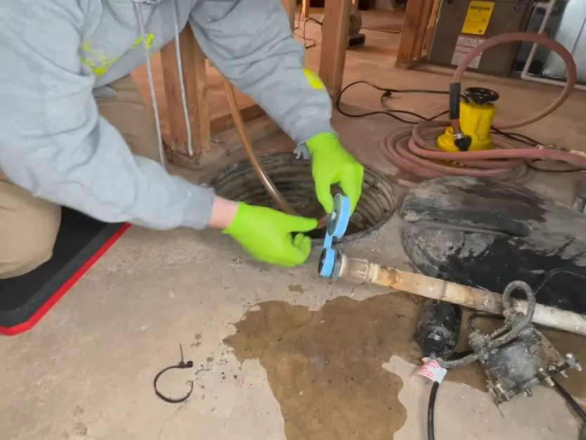 Sump pump basin, discharge pipe, and pump components during a plumbing service visit in La Vina on the lv-side-01 section