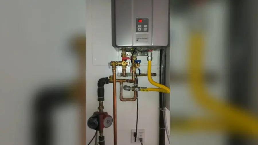 Residential water heater tank, supply lines, and service fittings during a plumbing service visit in East Altadena